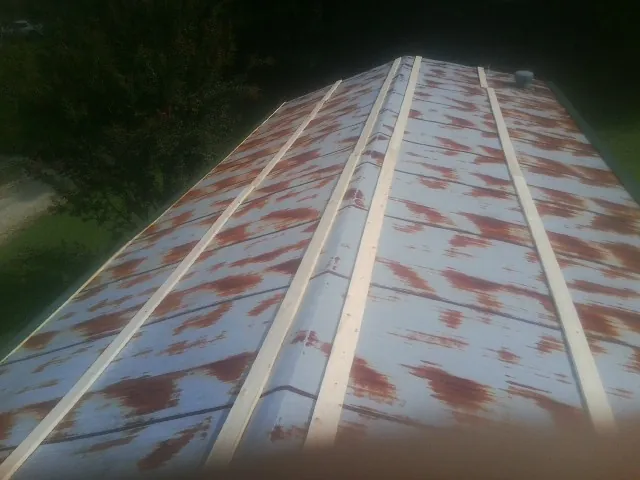 Rusted metal roof panels with new wood purlins before replacement — Storm Damage Roof Repair in Dime Box by Roofing Brothers