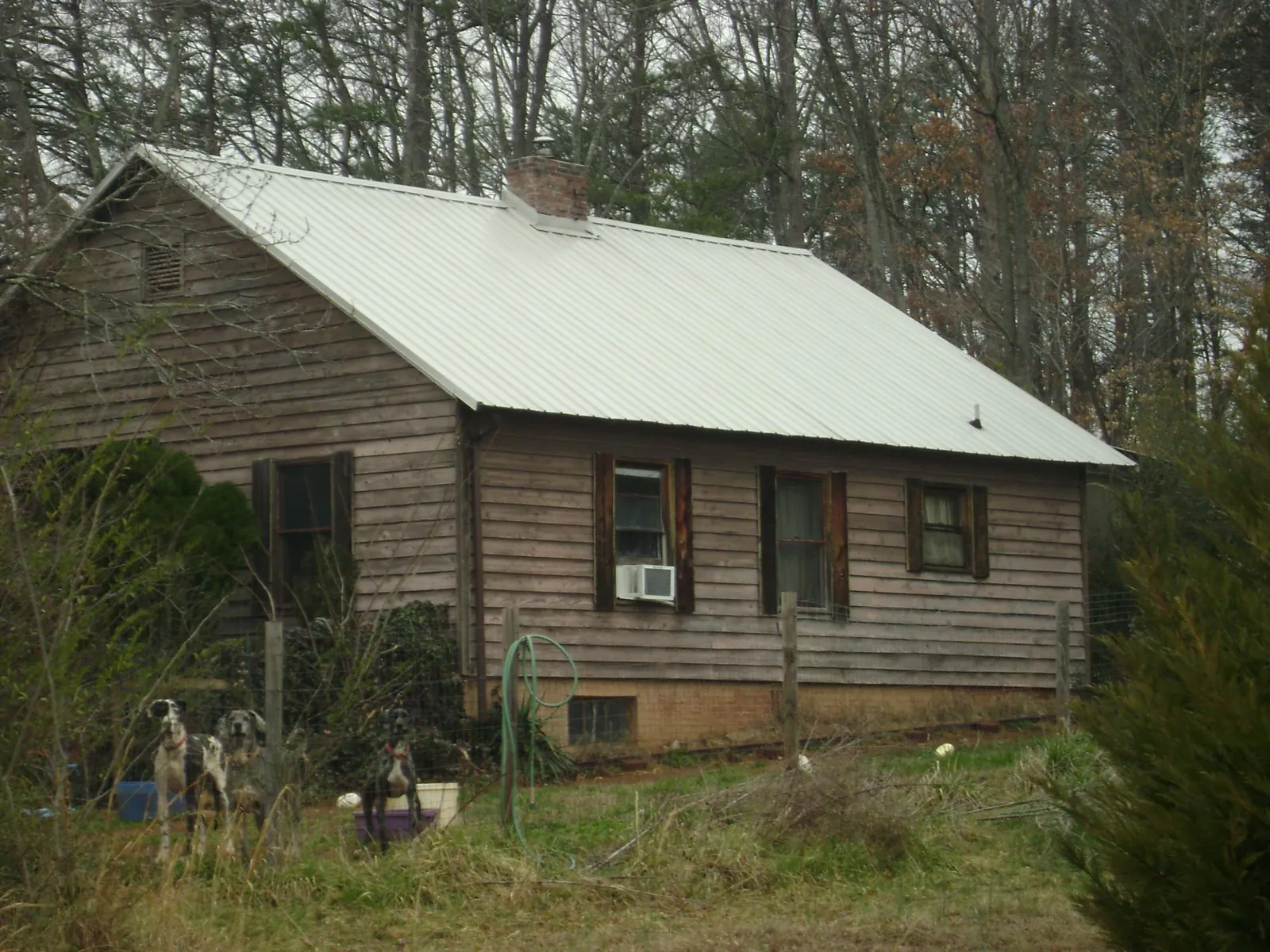 White metal roof on an old wood sided farmhouse, from a Metal Roof Installation job in Dime Box